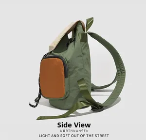 Side view of olive green waterproof backpack with orange pocket and beige flap detail