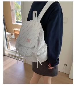 Detail view of large capacity white canvas backpack with pink star print and drawstring lid