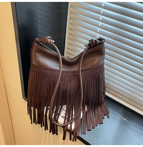 Dettaglio della borsa a tracolla marrone scuro con frange lunghe e inserti in pelle scamosciata