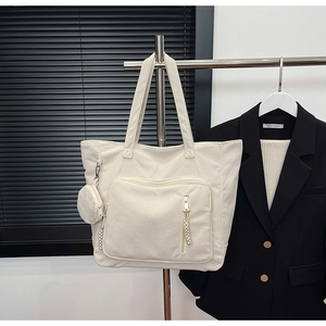 Dettaglio della borsa tote in velluto a coste bianco crema con borsellino e zip