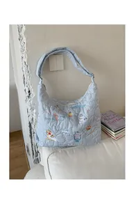 Gros plan du sac cabas matelassé bleu clair avec broderies cartoon et motifs de cœur