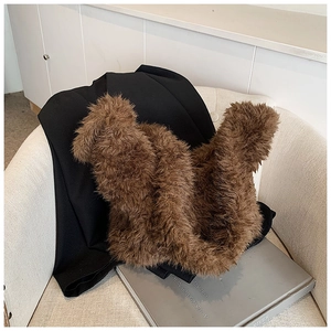Close-up of brown plush bucket bag on a white chair showing soft faux fur texture