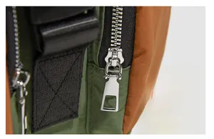Macro shot of silver metal zipper and durable olive nylon fabric on the backpack