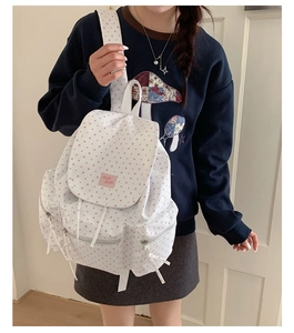 Close-up of white star-patterned backpack featuring multiple pockets and durable zippers