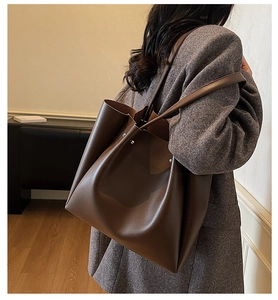 Detail of dark brown matte tote bag showing side metal buckle and large capacity capacity