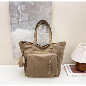 Dettagli del tessuto della borsa tote in velluto marrone con tasca anteriore e borsellino