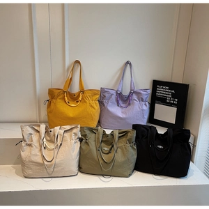 Group display of lightweight tote bags in five colors with drawstring side details
