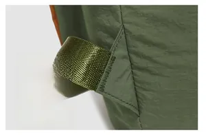 Macro shot of reinforced bartack stitching on army green waterproof nylon backpack