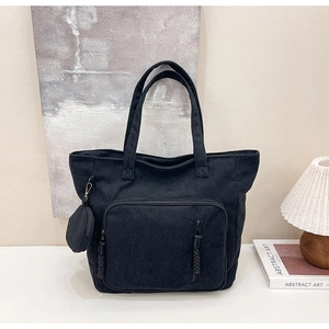 Dettaglio della borsa tote in velluto a coste nero con tasca a zip e portamonete rotondo