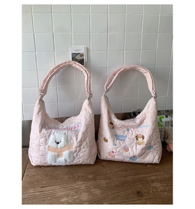 Détail de sacs matelassés roses avec broderies Lucky Puppy et Pudding Puppy