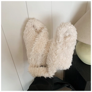 Close-up of soft off-white plush faux fur texture on a cozy autumn winter handbag
