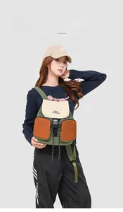 Detail of multi-color canvas backpack with double front zippers and buckle closure
