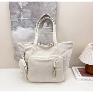 Dettaglio borsa tote in velluto a coste bianco crema con tasca zip e mini astuccio