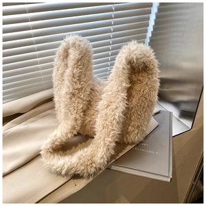 Detailed view of plush rabbit ear tote bag in beige faux fur on a cozy background