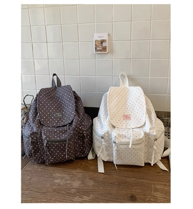 Detailed close-up of canvas backpacks featuring star patterns and multi-pocket design
