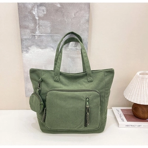 Dettaglio della borsa tote in velluto verde con tasca a zip e portamonete rotondo extra