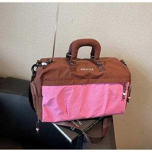 Détail du sac de voyage en nylon rose et marron avec tirette de fermeture tissée