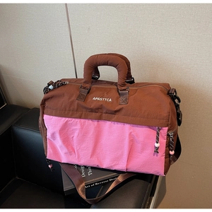 Détail de la texture en nylon résistant à l'eau et logo sur le sac de voyage rose