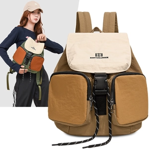 Detail view of the khaki multi-pocket backpack showing buckle and textured fabric