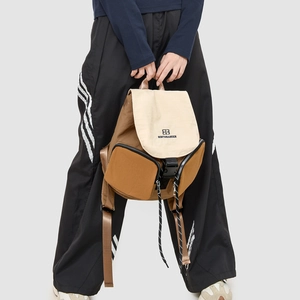 Detail view of a two-tone nylon hiking backpack with buckle flap and side zippers