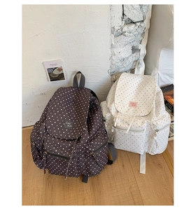 Detail of star-patterned backpacks with front pockets and adjustable straps in lifestyle setting