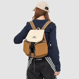 Detail of waterproof nylon backpack with brown and beige color-block and buckled pockets
