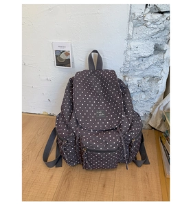 Detail of grey star pattern backpack featuring k&d hello patch and zipper pocket