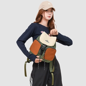 Detail view of a multi-pocket green and beige backpack with orange zipper pockets