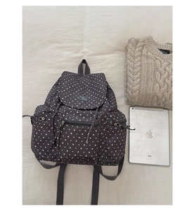 Flat lay of star-patterned gray backpack with iPad and sweater on soft fabric