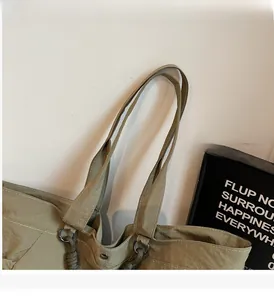 Detail of olive green tote bag showing durable nylon handles and reinforced stitching