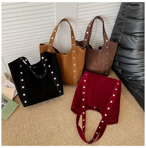 Close-up of four suede tote bags with rivet straps in black, khaki, brown and burgundy