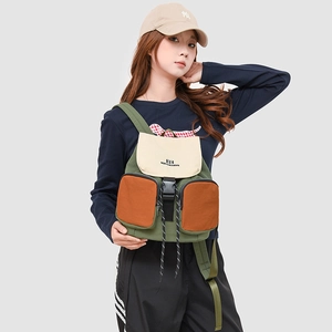 Detail view of multi-color canvas backpack on model with olive green and beige panels