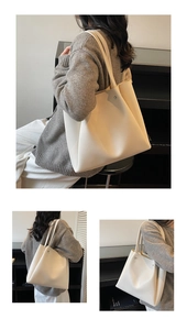 Detail view of large cream tote bag showing smooth leather texture and silver rivets