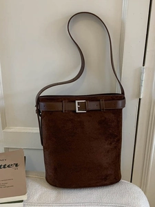 Sac seau minimaliste en daim marron foncé avec bandoulière réglable et boucle argentée