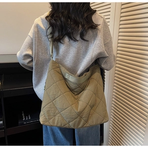 Detail of olive green quilted tote bag showing wide strap and large capacity texture