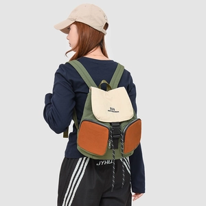 Outdoor backpack detail showing dual side zipper pockets and canvas texture on back