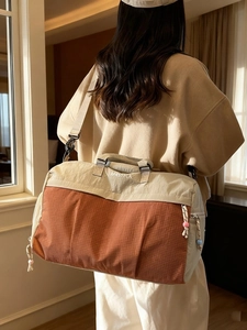 Sac de voyage spacieux en patchwork beige et rouge avec bandoulière et texture nylon