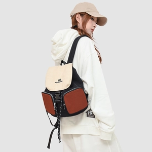 Detail view of the multi-pocket patchwork backpack showing side profile and buckles