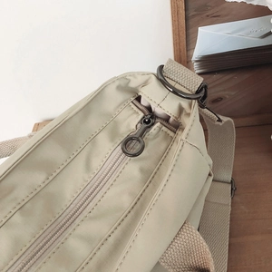 Close-up of nylon tote bag with metal ring zipper and stylish woven shoulder strap