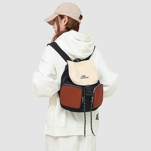Close-up of tricolor hiking backpack showing buckle straps and drawstring details