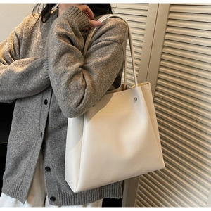 Minimalist beige tote bag shoulder view showing large capacity and sleek PU leather design