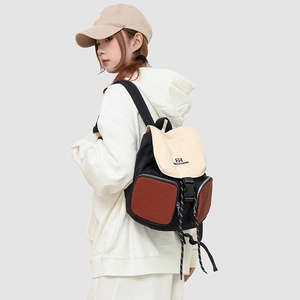Detail view of the multi-color canvas backpack showing buckle closure and drawstring design