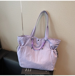 Detail view of large light purple tote bag with crinkled nylon texture and side pocket