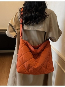 Quilted orange oversized tote bag with diamond pattern and adjustable wide shoulder strap