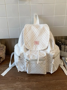 White canvas backpack with pink star patterns and spacious compartments for travel