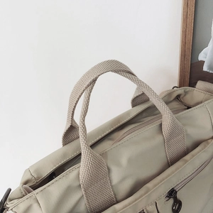 Close-up of durable nylon shoulder bag with premium zipper and sturdy webbing handle