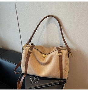 Vue détaillée du double zip doré et de la texture en daim du sac fourre-tout camel