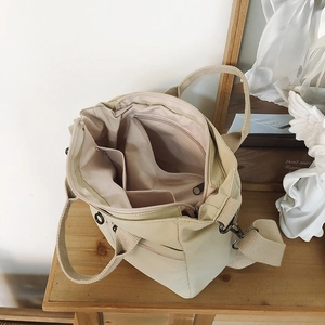 Top view of beige nylon tote bag interior showing spacious compartments and zip pocket