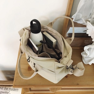 Internal view of beige nylon tote bag showing multiple pockets and spacious storage space