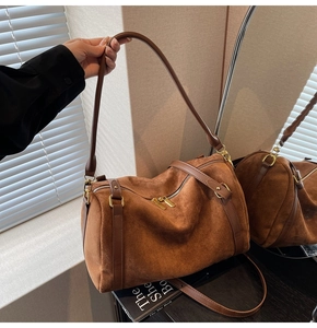 Détails de la texture du daim marron et des finitions dorées sur le grand sac cabas